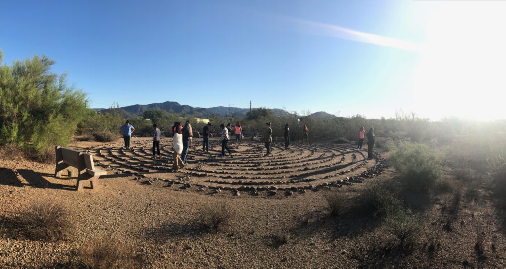 Women walk a prayer labyrinth in the hot Arizona sun