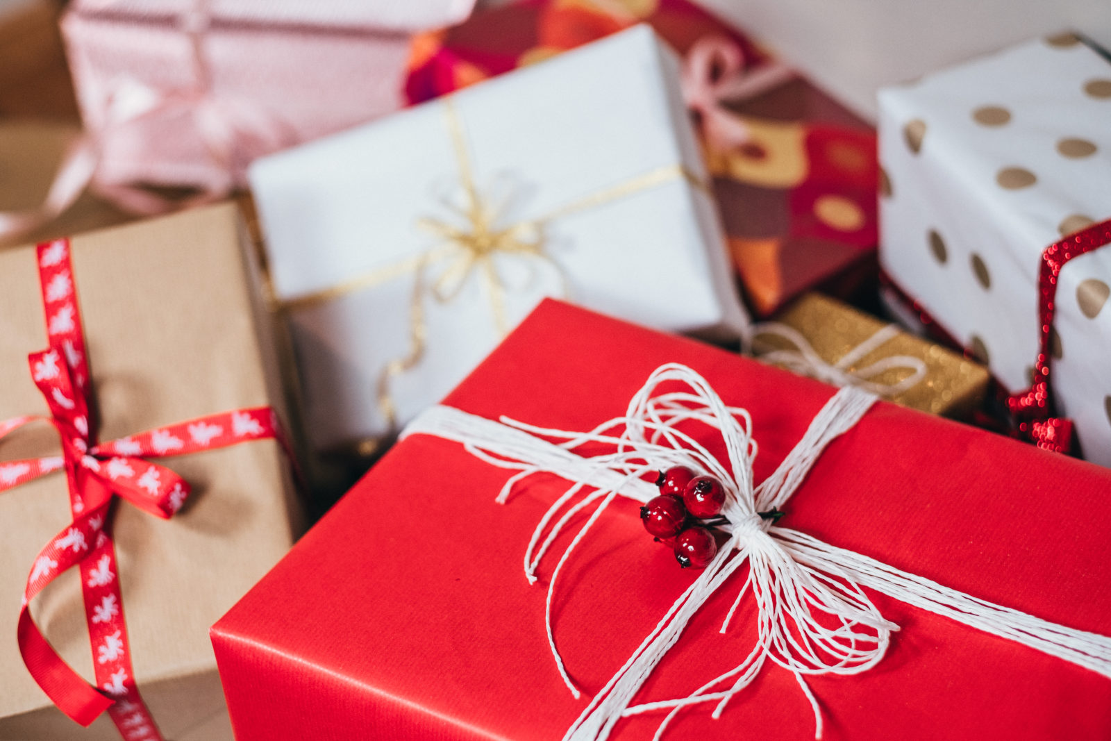 Christmas gifts in red, white, and brown paper with bows