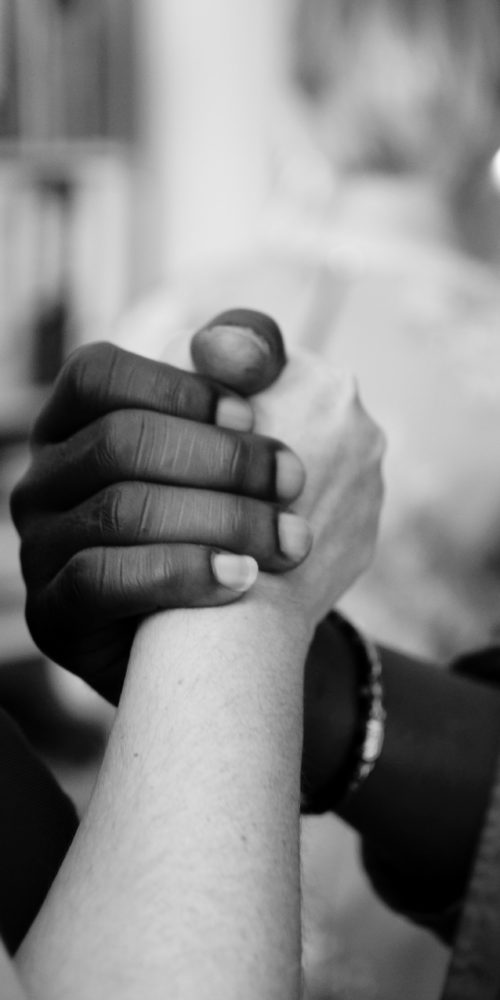 grayscale photo of man and woman holding their hands