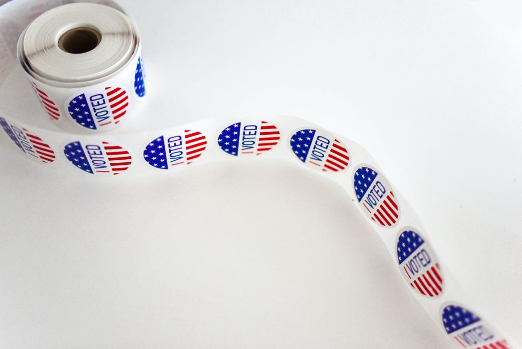 A roll of "I voted" stickers across a white background