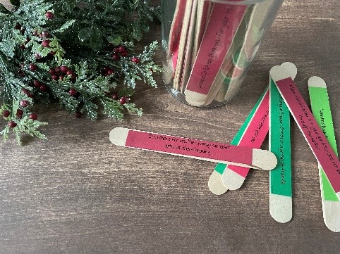 wooden popsicle sticks have random acts of kindness written on red and green paper