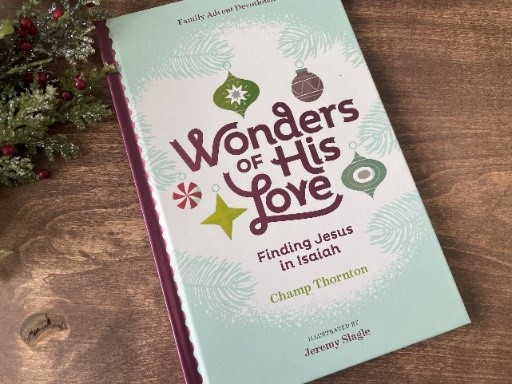 Wonders of His Love book by Champ Thornton next to Christmas wreath