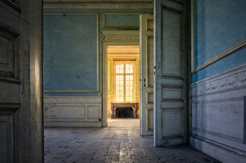 los portales de madera blanca revelan una habitación luminosa en un edificio antiguo