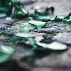 a mess of broken green glass on cement tile floor