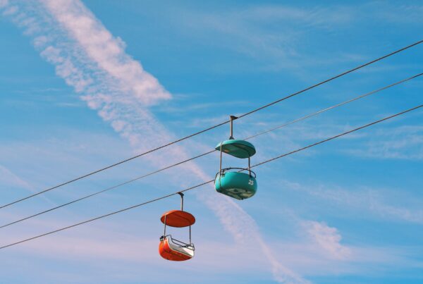 two air trolley carts pass by each other against blue sky