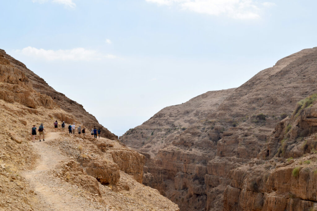 travelers walk along the dry, dusty Jericho Road