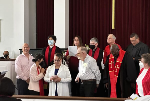 los líderes de una iglesia con túnica rezan para que una mujer sea nombrada pastora