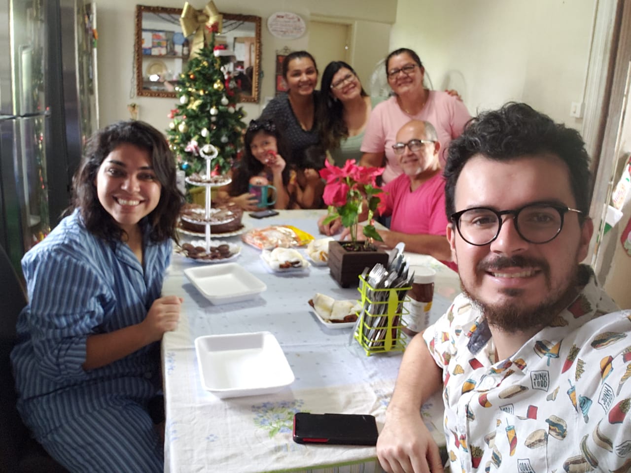 seven smiling people around table on Christmas morning