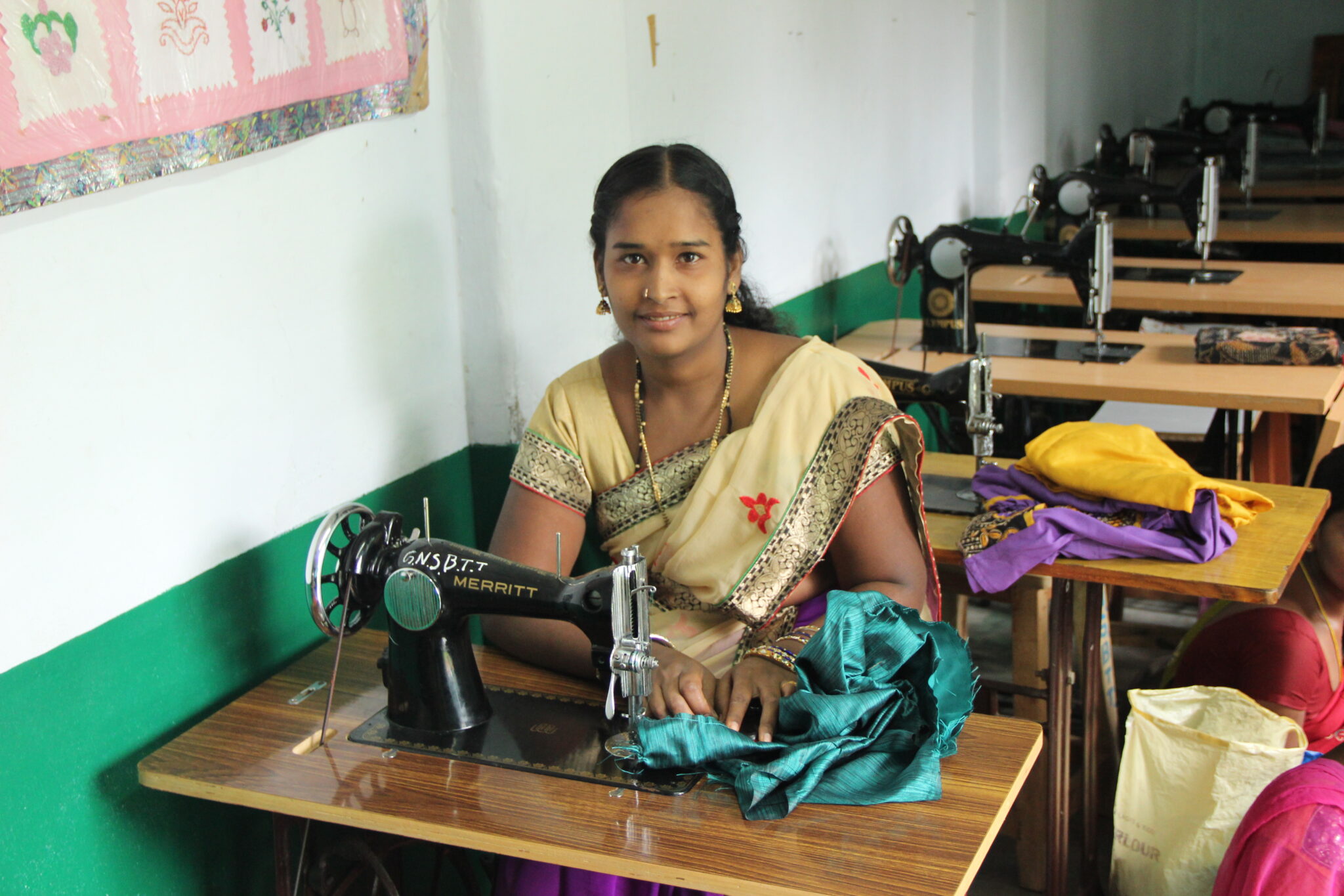 una mujer en la India se sienta a la mesa con una máquina de coser