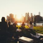 un grupo de cinco personas conversan sentadas al aire libre con el horizonte de la ciudad de fondo