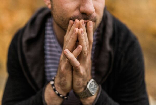 close up of man's hands in contemplative prayer posture