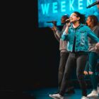 woman sings and leads church worship with team behind her